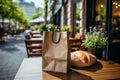 A loaf of freshly baked wheat bread and a craft paper bag lie on the table of a street cafe, bakery and confectionery Royalty Free Stock Photo