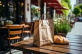 Loaf of freshly baked wheat bread and a craft paper bag lie on the table of a street cafe, bakery and confectionery Royalty Free Stock Photo