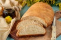 A loaf of healthy wholewheat bread on a serving board served with honey and mimosa