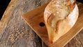Loaf of home-made cereal bread on a cutting board on an  wooden background. Royalty Free Stock Photo