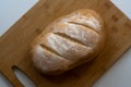 A loaf of homemade baked sourdough bread with three parallel cuts scoring