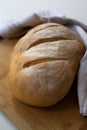 A loaf of homemade baked sourdough bread with three parallel cuts scoring