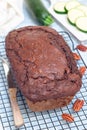 Loaf of homemade chocolate zucchini or courgette bread with pecan nuts, on cooling rack, vertical Royalty Free Stock Photo
