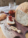 loaf of homemade whole grain bread and a cut slice of bread on a wooden cutting board. A mixture of seeds and whole Royalty Free Stock Photo