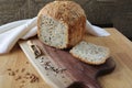 loaf of homemade whole grain bread and a cut slice of bread on a wooden cutting board. A mixture of seeds and whole Royalty Free Stock Photo