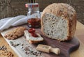 loaf of homemade whole grain bread and a cut slice of bread on a wooden cutting board. A mixture of seeds and whole Royalty Free Stock Photo