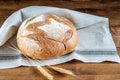 Loaf of integral bread on the kitchen napkin and on the wooden table. Healthy grain bread