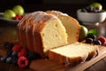 a loaf of lemon pound cake on a cutting board with berries and a bowl of green apples in the backgrouf of the photo Royalty Free Stock Photo