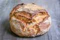 Loaf or miche of French sourdough, called as well as Pain de campagne, on display on a wooden table.