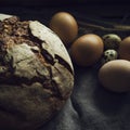 Loaf of rye bread with chicken eggs in wooden box, selective focus Royalty Free Stock Photo