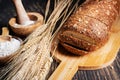 loaf of rye bread, ears of wheat and a bowl of flour. Close-up Royalty Free Stock Photo