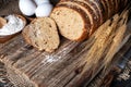 loaf of rye bread, ears of wheat, eggs and a bowl of flour. Close-up Royalty Free Stock Photo