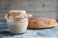 Loaf rye bread and sourdough on whole grain flour in glass jar on table, yeast-free leaven starter for organic bread Royalty Free Stock Photo