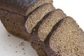 Loaf and slices of black bread on white background