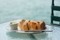 Loaf of sourdough bread with butter on glass table