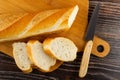 Loaf of bread, slices of bread, knife on cutting board on wooden table. Top view Royalty Free Stock Photo