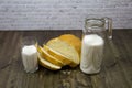 A loaf of white bread sliced with a decanter glass of milk on a table of brown boards. Royalty Free Stock Photo