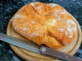 Wheat bread, knife on a wooden board Royalty Free Stock Photo