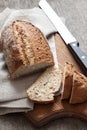 Loaf of whole wheat bread with slices on wooden board Royalty Free Stock Photo