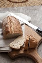 Loaf of whole wheat bread with slices on wooden board Royalty Free Stock Photo