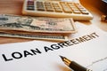 Loan agreement, money and calculator on a desk. Royalty Free Stock Photo