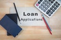 Loan Applications sign with check books pencils and calculators financial industry background