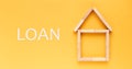 loan concept. house laid out of wooden blocks with the inscription loan on a yellow background.