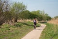 Loan male cyclist wearing cycling clothing seen following a bike trail at a designated conservation area.