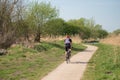 Loan male cyclist wearing cycling clothing seen following a bike trail at a designated conservation area.