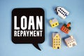 Loan Repayment text with house models on blue background Royalty Free Stock Photo
