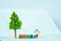 LOAN text and small model house and little tree with notebook, s