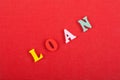 LOAN word on red background composed from colorful abc alphabet block wooden letters, copy space for ad text. Learning english