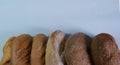 loaves of bread from the bakery on a light background. Variety of loaves, baguettes. Royalty Free Stock Photo