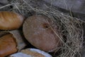 loaves of bread from the bakery in the store. Burlap and straw with pastries. Various loaves, baguettes. Royalty Free Stock Photo