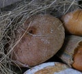 loaves of bread from the bakery in the store. Burlap and straw with pastries. Various loaves, baguettes. Royalty Free Stock Photo