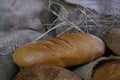 loaves of bread from the bakery in the store. Burlap and straw with pastries. Various loaves, baguettes. Royalty Free Stock Photo