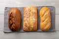 Loaves of fresh hommade whole bread on gray napkin flat lay on white wooden background Royalty Free Stock Photo