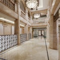 The lobby of a luxury hotel in Arabic style with high ceilings, columns and a reception desk with a seating and waiting area