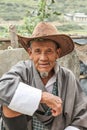 Lobesa Village, Punakha, Bhutan - September 11, 2016: Unidentified smiling old man with hat sitting at weekly farmers market
