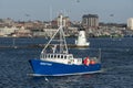 Lobster boat Direction passing lighthouse in New Bedford harbor Royalty Free Stock Photo