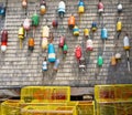 Lobster buoys hanging on the wall of a building with yellow lobster pots on the ground Royalty Free Stock Photo