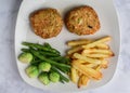 lobster cakes with french fries and vegetables