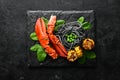 Lobster claw with black pasta and vegetables on the black stone plate. Seafood. Top view. Royalty Free Stock Photo