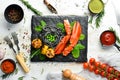 Lobster claw with black pasta and vegetables on the black stone plate. Seafood. Top view. Royalty Free Stock Photo