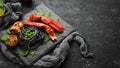 Lobster claw with black pasta and vegetables on the black stone plate. Seafood. Top view. Royalty Free Stock Photo