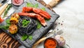 Lobster claw with black pasta and vegetables on the black stone plate. Seafood. Top view. Royalty Free Stock Photo