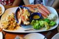 Lobster, crab and a lemon wedge and served with wild rice and couscous and broccolini.