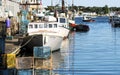 Lobster fishing boats docked in a canal with lobster traps pilled on the dock in Portland Maine Royalty Free Stock Photo