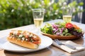 lobster roll served alongside a light salad on a patio Royalty Free Stock Photo