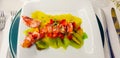 lobster salad with lobster and a bed of strawberries kiwis and pieces of pineapple